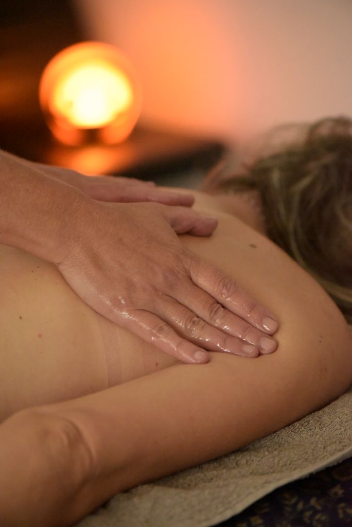 Séance de massage énergétique avec huiles tièdes dans un cabinet apaisant