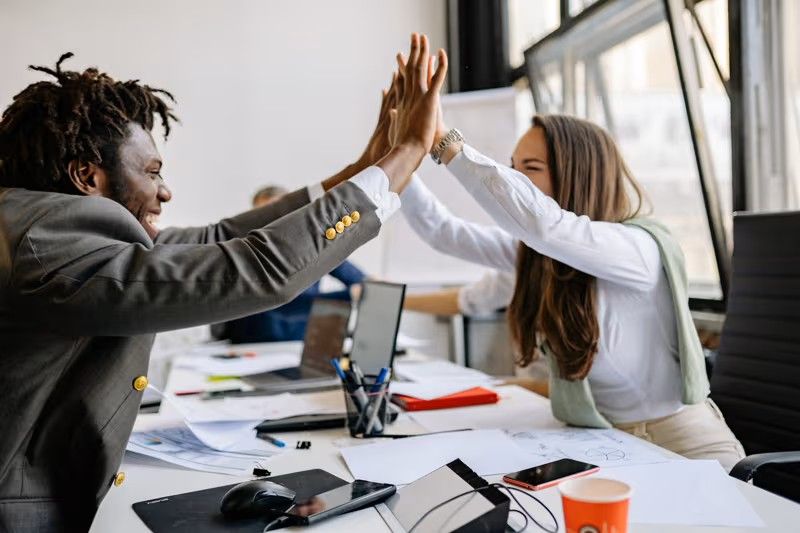 Entrepreneur indépendant travaillant sereinement à son bureau, entouré de documents organisés et d'un ordinateur, illustrant la maîtrise retrouvée de son activité