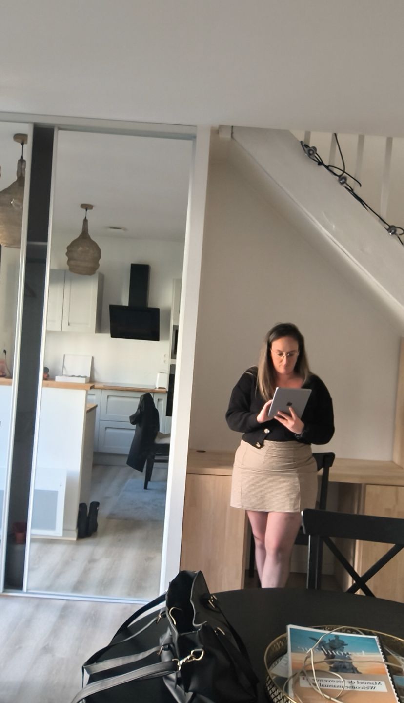 Femme travaillant sereinement sur son ordinateur depuis chez elle, avec ses enfants qui jouent à côté